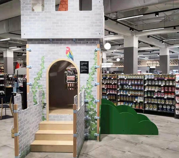 Op deze afbeelding staat een custom kinderhoek in een supermarkt