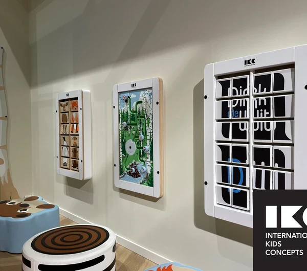 Children’s corner with interactive wall play panels and soft seating in a public waiting area