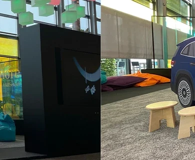 Kinderhoek in Mercedes-Benz showroom met interactieve speelobjecten, waaronder een blauw Mercedes-auto speelmeubel met wandspel, kleurrijke zitzakken en speeltafels, omgeven door grote glazen ramen en modern interieur.