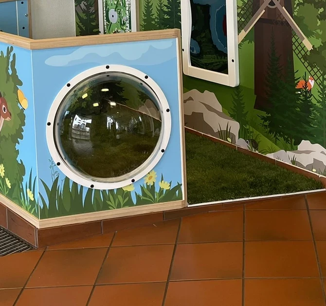 Interactive children’s play corner with farm-themed design, featuring a windmill, tunnel, and animal graphics
